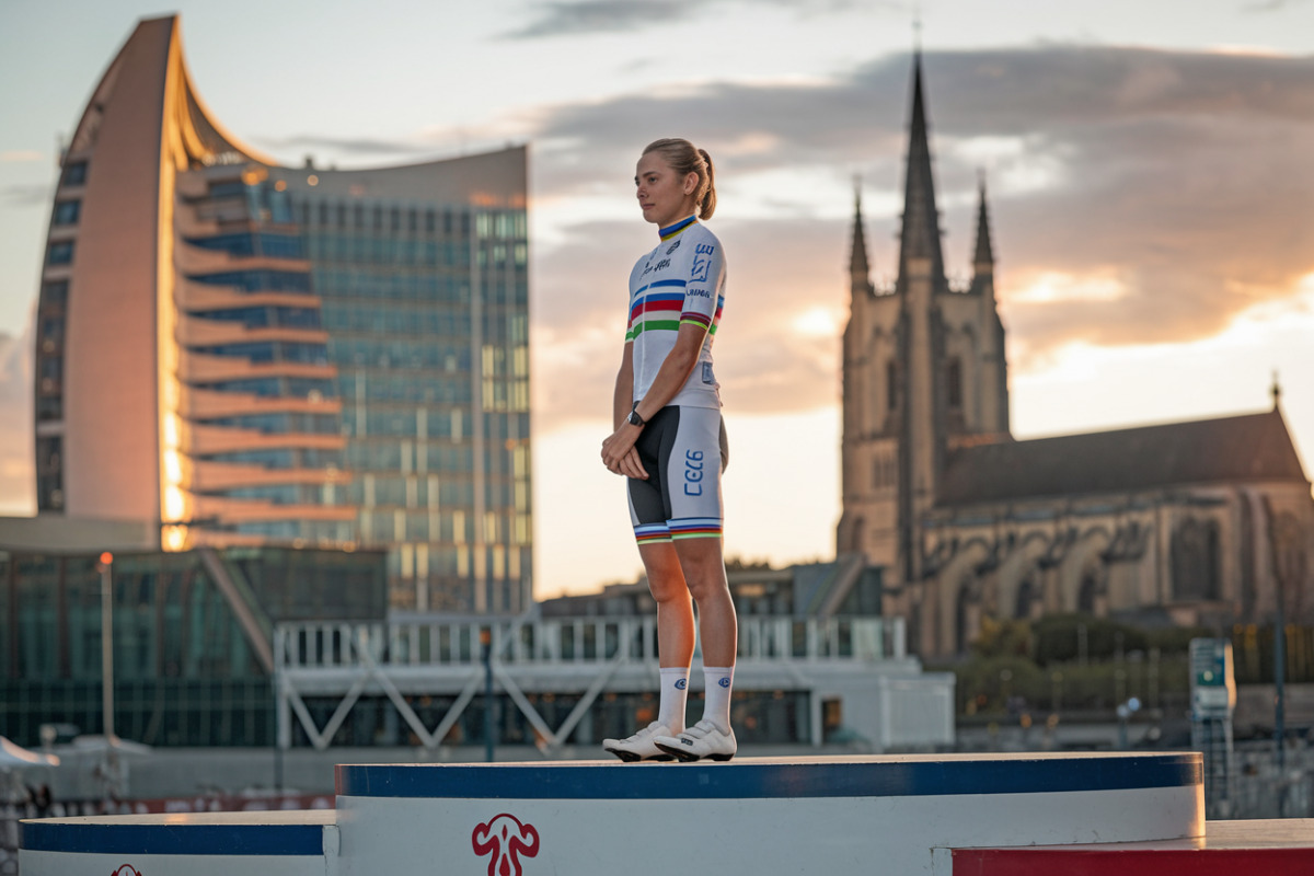 Célia Géry, jeune cycliste française, levant les bras en triomphe sur la ligne d'arrivée.