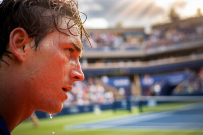 Tennismen américains s'affrontant sur court de gazon lors d'un tournoi ATP professionnel.