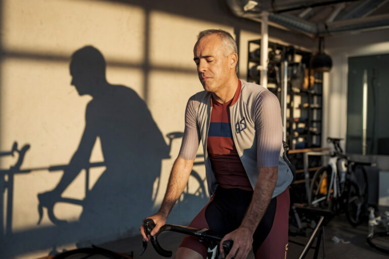 Iniesta en tenue cycliste sur un vélo de route, entouré de coureurs professionnels surpris.
