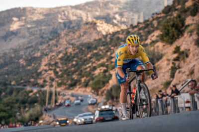Pogacar en maillot jaune franchit la ligne d'arrivée alpine, bras levés en victoire.