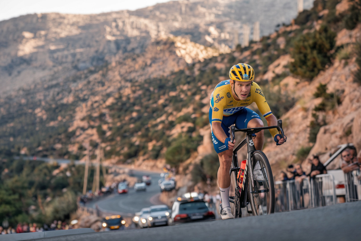 Pogacar en maillot jaune franchit la ligne d'arrivée alpine, bras levés en victoire.