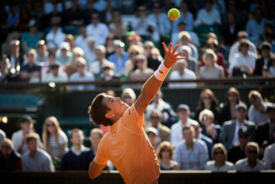 Rinderknecht et Djokovic s'affrontent sur le court de tennis pendant leur match intense.