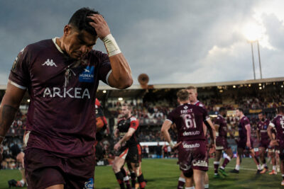 Joueurs de Bordeaux-Bègles en maillot noir et blanc affrontant Gloucester au rugby.